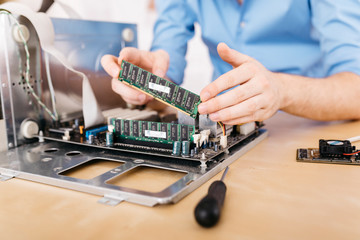 Close-up of technician repairing a desktop computer, changing the computer's RAM