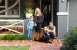 © Caro Telfer/Austockphoto - Family with pet dog in front of suburban home