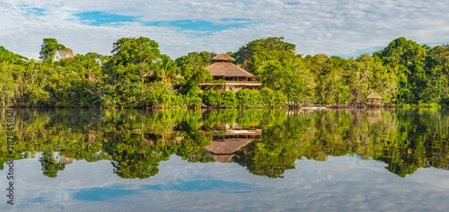 Panoramic rainforest lodge reflection. The tributaries of the Amazon river comprise the countries of Suriname, Guyana, French Guyana, Venezuela, Colombia, Ecuador, Peru, Bolivia and Brazil.