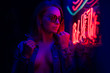 © Anton - Sexy portrait of a young girl in sunglasses and with in the night city, with creative light on the background of neon lamps. Night clubs, parties, strip business, night life.