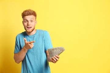 Wall Mural - Portrait of surprised lottery winner with money on yellow background, space for text