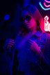 © Anton - Sexy portrait of a young girl with an open bust in sunglasses and with in the night city, with creative light on the background of neon lamps.Night clubs, parties, strip business, night life