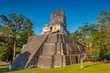 The main square of the Mayan Tikal archaeological site with the impressive Temple II pyramid midst of the Peten rainforest near the city of Flores, Guatemala.