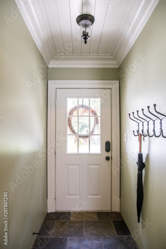 Green Long Hallway With Shiplap Ceiling And A Door With A Window
