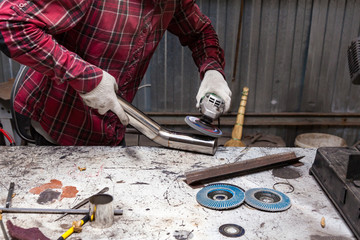 Wall Mural - Surface preparation of stainless steel pipes using an angle grinder for further welding in an iron workshop. Industry and production.