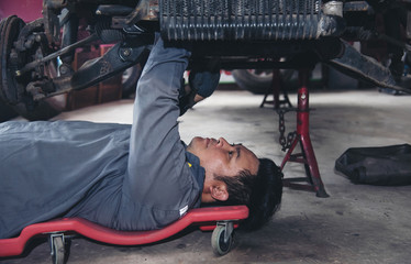 asia handsome mechanic in uniform is working in auto service.