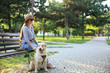 Young blind woman with guide dog in park