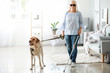 Blind mature woman with guide dog at home