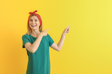 Poster - Stylish beautiful woman pointing at something on color background