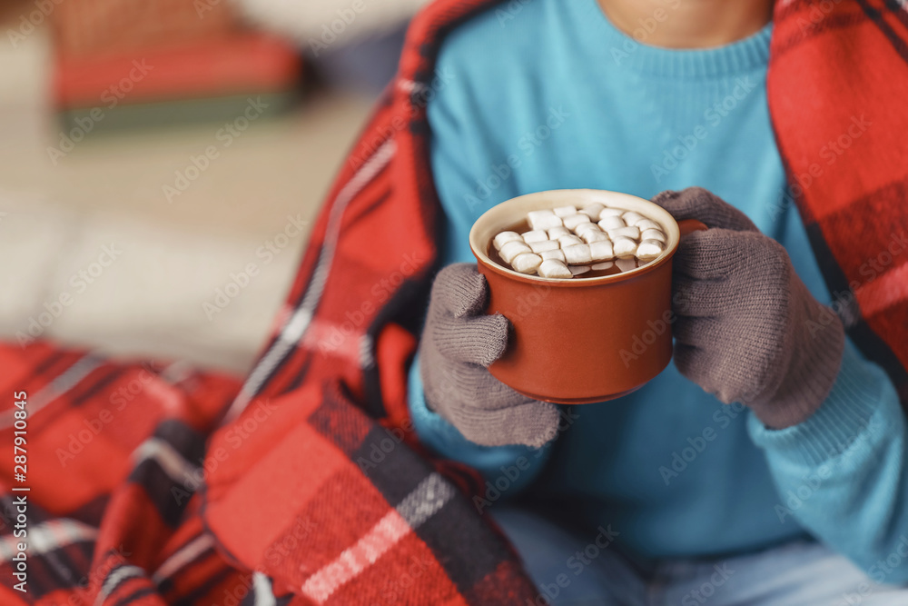 Cute little boy with hot chocolate in cup, closeup
