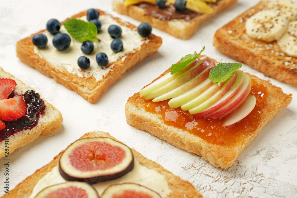 Different tasty sandwiches on light background