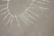 Chalk drawing of sun on asphalt. Children's creativity in the summer, the development of imagination.