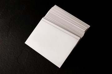 Wall Mural - A mock-up of a stack of white business cards on a black slate background