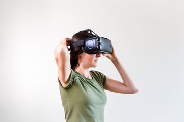 Brunette woman exploring modern technology virtual reality with head mounted display on white background