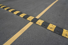 Yellow Paint Line And Speed Bump Line On Asphalt Road