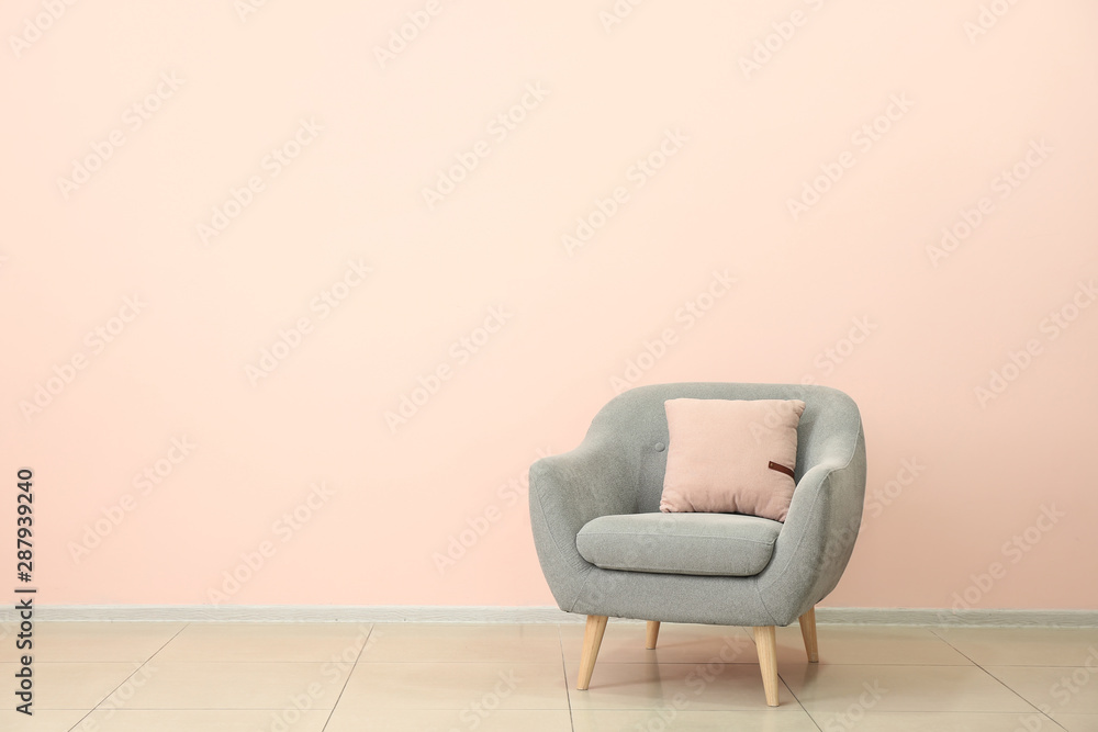 Comfortable armchair near color wall