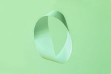 Mobius Strip Made From Paper Soaring In The Air On Neo Mint Background. Trendy Surreal Airy Image. Abstract Color Concept Composition With Copy Space. Color Of The Year 2020.