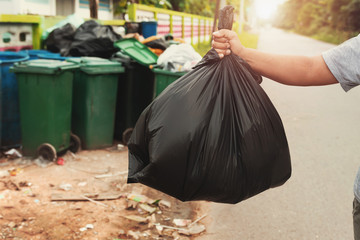 Wall Mural - woman hand holding garbage in black bag for cleaning in to trash