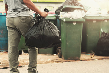 Wall Mural - woman hand holding garbage in black bag for cleaning in to trash