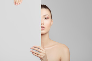 Wall Mural - woman holds a banner covering part of her face. Clean healthy skin concept