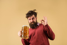 Bearded Drunk Hipster Male Holds Craft Beer. Bad Habits. Bearded Man Drinking Beer From Glass Shows Ok Sign. Drinks, Alcohol, Leisure And People Concept. Stylish Man With Beard Holds Mug Of Beer.