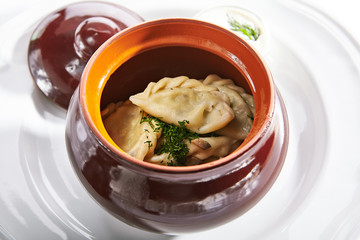 Traditional Polish Dumplings in a clay Ceramic Pot