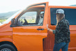 © karrastock - young woman standing in desert with van door open
