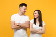 © ViDi Studio - Young couple two friends guy girl in white empty blank t-shirts posing isolated on yellow orange background. People lifestyle concept. Mock up copy space. Holding hands crossed, looking at each other.