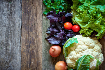 Wall Mural - Fresh vegetables and herbs on an old rough wooden surface, healthy eating concept, selective focus