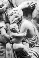 Sticker - Detail of ancient engraved sculpture on marble showing woman protecting child - black and white photo