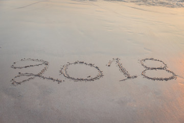 Wall Mural - Numbers 2018 handwritten on sand at the beach during sunset time