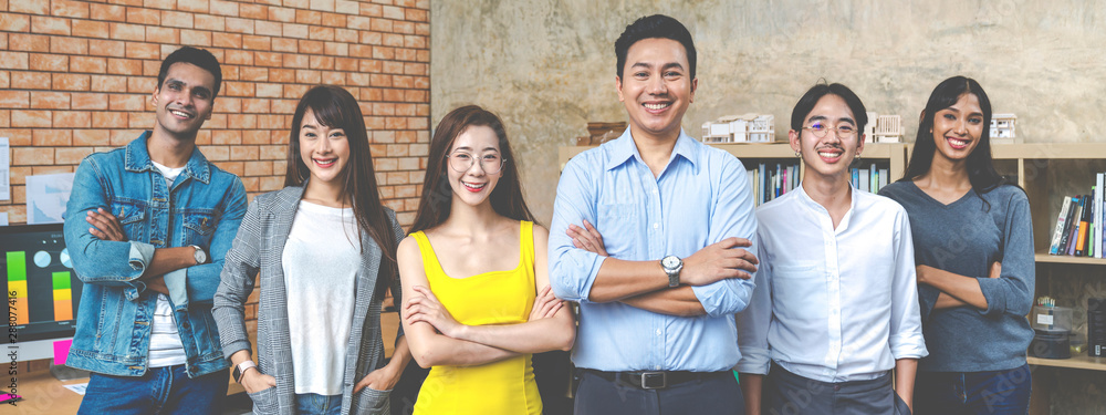 Banner of Group asian employee are standing and looking at camera with feeling confident at workplace company. Portait of Asian creative team posing in workspace. - obrazy, fototapety, plakaty 