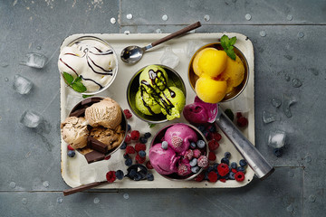 Poster - Assorted flavors and colors of gourmet Italian ice cream served on steel table. Mango, chocolate, green matcha ice cream