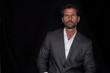 © Israel - Green-eyed, handsome and sexy  businessman posing with jacket and shirt and black background