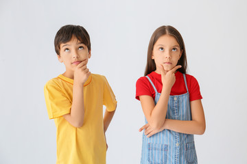 Wall Mural - Portrait of thoughtful children on light background