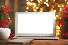 Wooden Desk With Computer With Blank Screen Against Blurred Christmas Lights Background