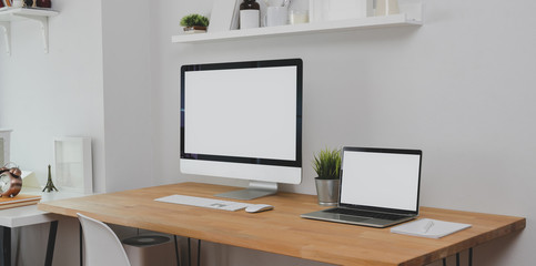 Trendy workplace with desktop computer, laptop computer and office supplies with decorations