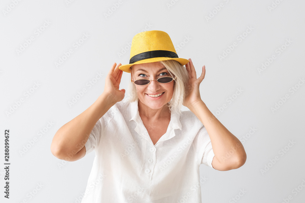 Stylish mature woman on light background