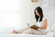 © Pixel-Shot - Beautiful young woman reading book in bedroom