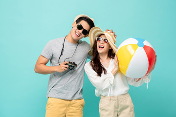 Lovely Asian couple in summer casual clothes and beach accessories