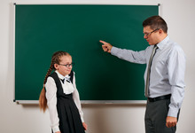 Angry Teacher Shout To Schoolgirl, Posing At Blackboard Background - Back To School And Education Concept