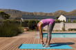 © WavebreakMediaMicro - Woman performing stretching exercise in the backyard of home