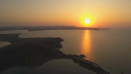 Wall Mural - Majestic sunset with huge orange sun over island shore line in Limnos, Greece