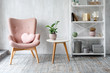 © Magryt - Stylish pink armchair with heart shaped pillow in a bright minimalist interior