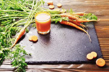 Wall Mural - Closeup view at fresh organic vegetarian carrot juice on wooden kitchen table