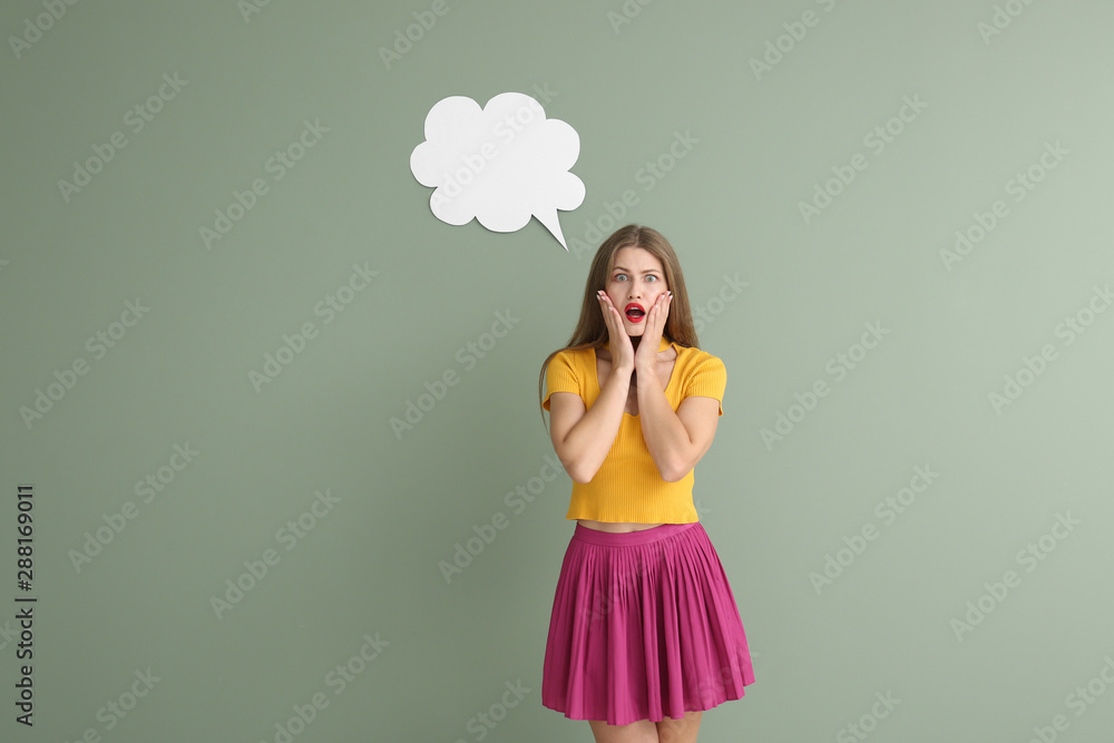 Shocked young woman with speech bubble on color background