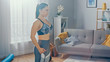 © Gorodenkoff - Shot of a Fit Beautiful Female in an Athletic Top Doing Breath Exercises in Her Bright and Spacious Living Room with Minimalistic Interior.
