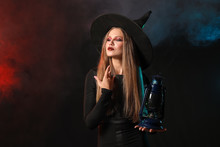 Beautiful Woman Dressed As Witch For Halloween On Dark Background