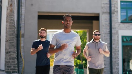 Wall Mural - fitness, sport and healthy lifestyle concept - young men or male friends running outdoors