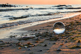 Fototapeta Mapy - Szklana kula na brzegu morza. Piękny wschód słońca